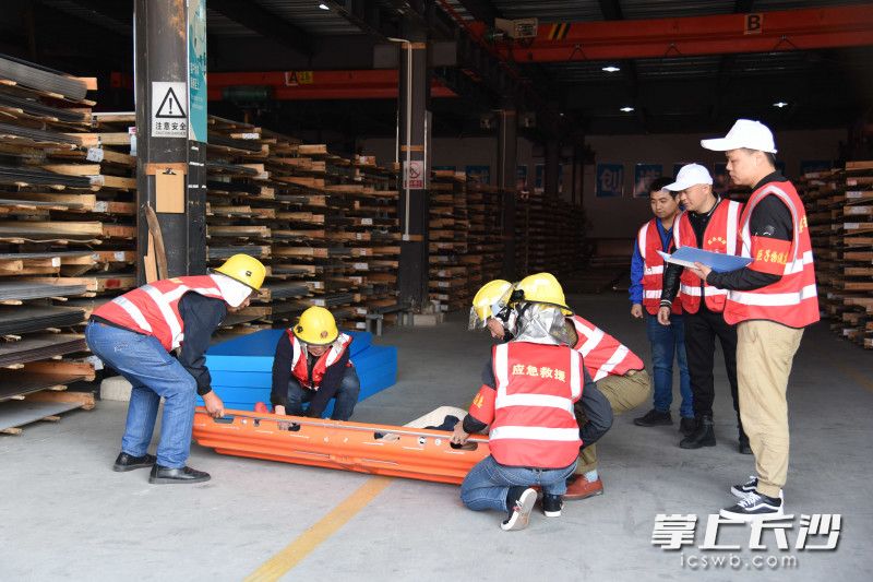 现场，工人将“伤者”抬上担架。