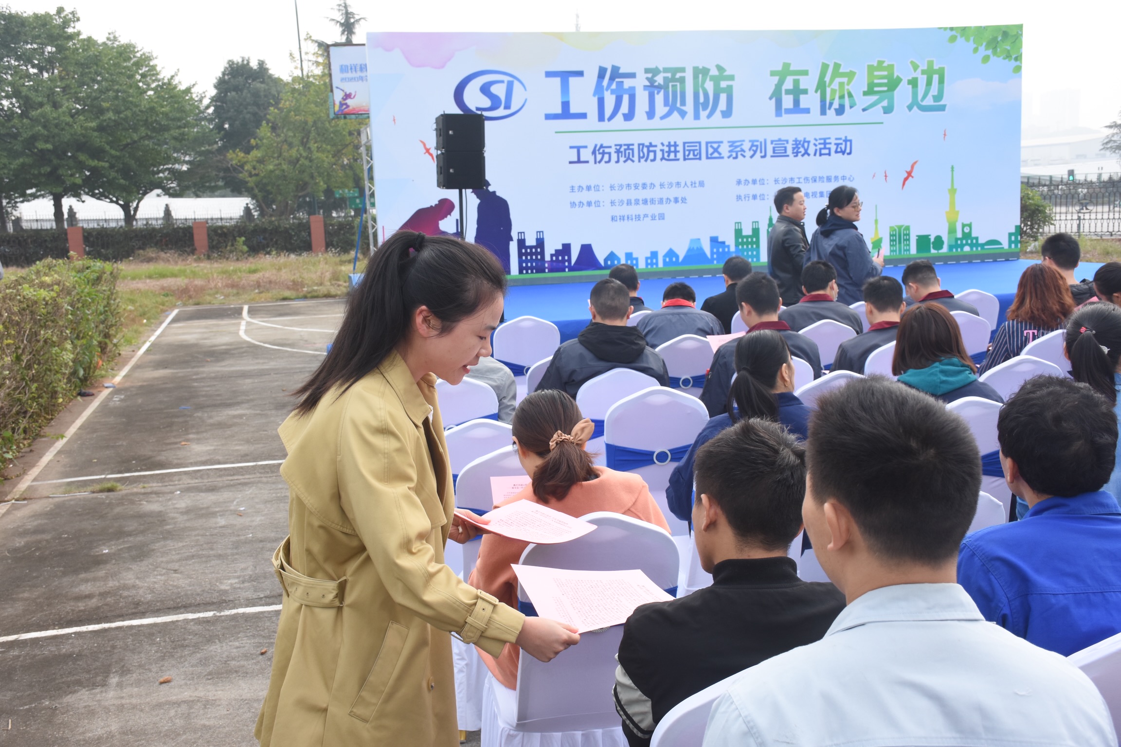 工作人员为园区企业职工发放工伤预防宣传资料。