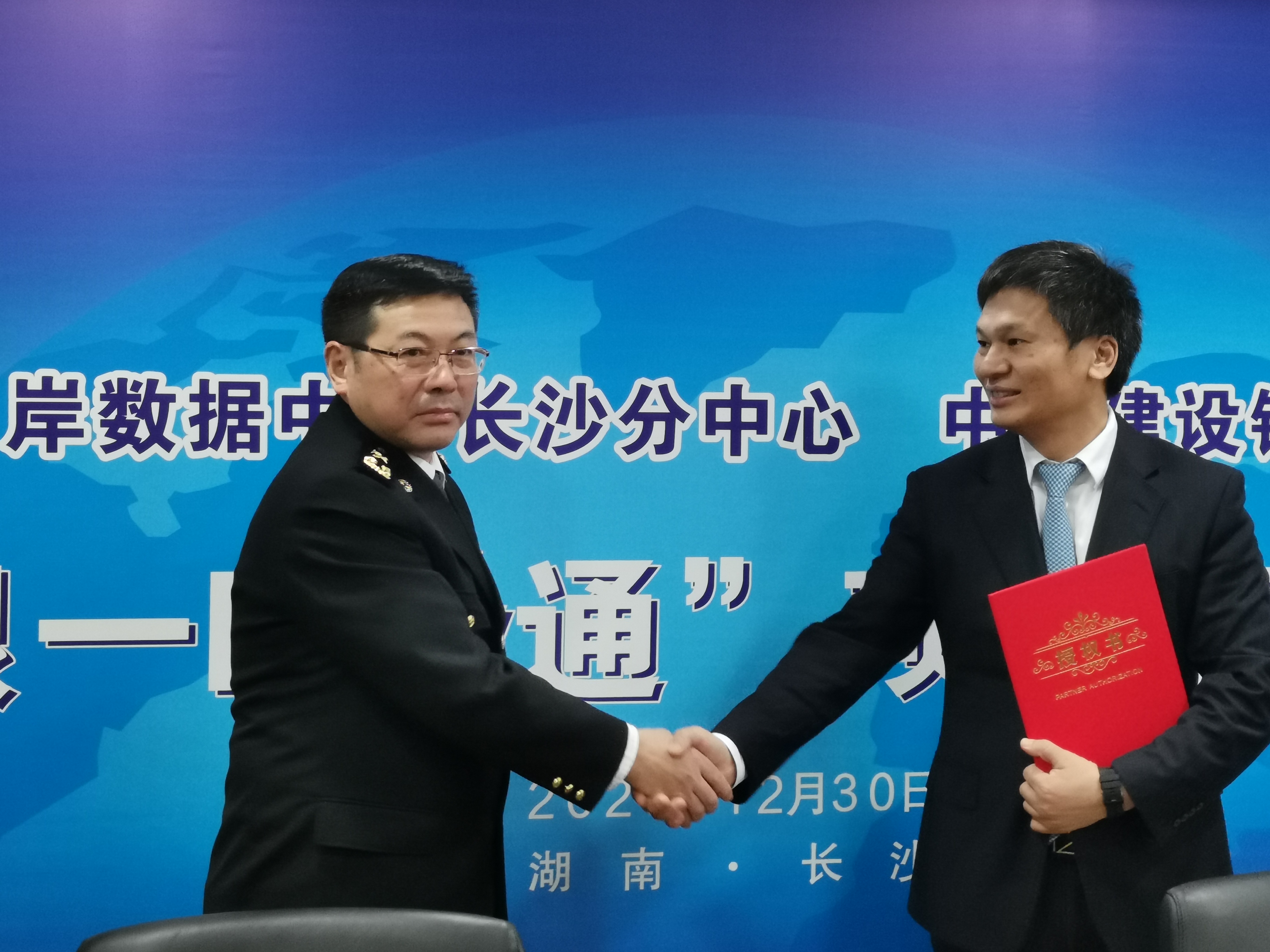 长沙海关副关长黄志强（左）向中国建设银行湖南省分行副行长文志军颁发电子口岸合作制卡代理点代理委托授权书。 长沙晚报全媒体记者 曹开阳 摄