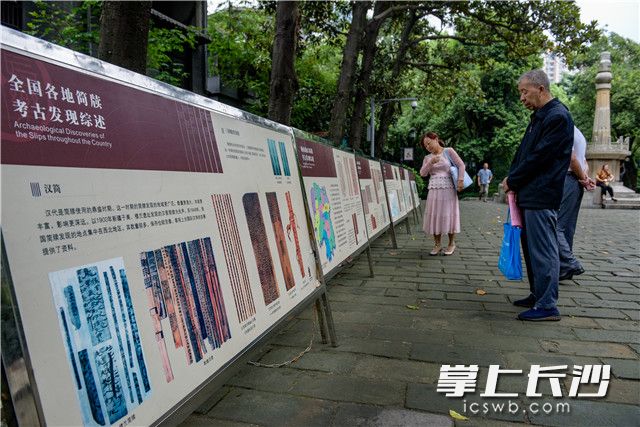 市民细细品读文化展板展示的传统文化魅力