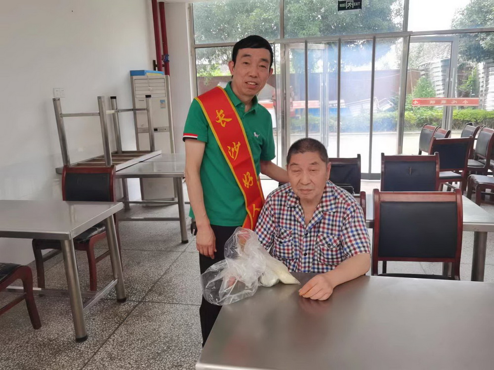 长沙好人王罗生将精心准备的爱心物资送到了老人手中