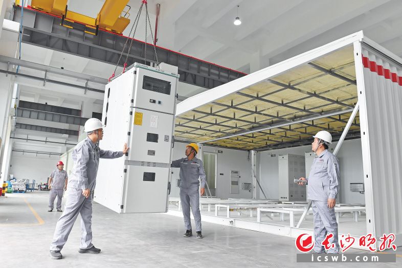 日前,湘能楚天集成车间内,工作人员正在吊装预制舱内相关设备。 日前,湘能楚天集成车间内,工作人员正在吊装预制舱内相关设备。